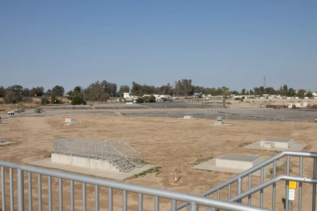 A view of an empty field with a railing.