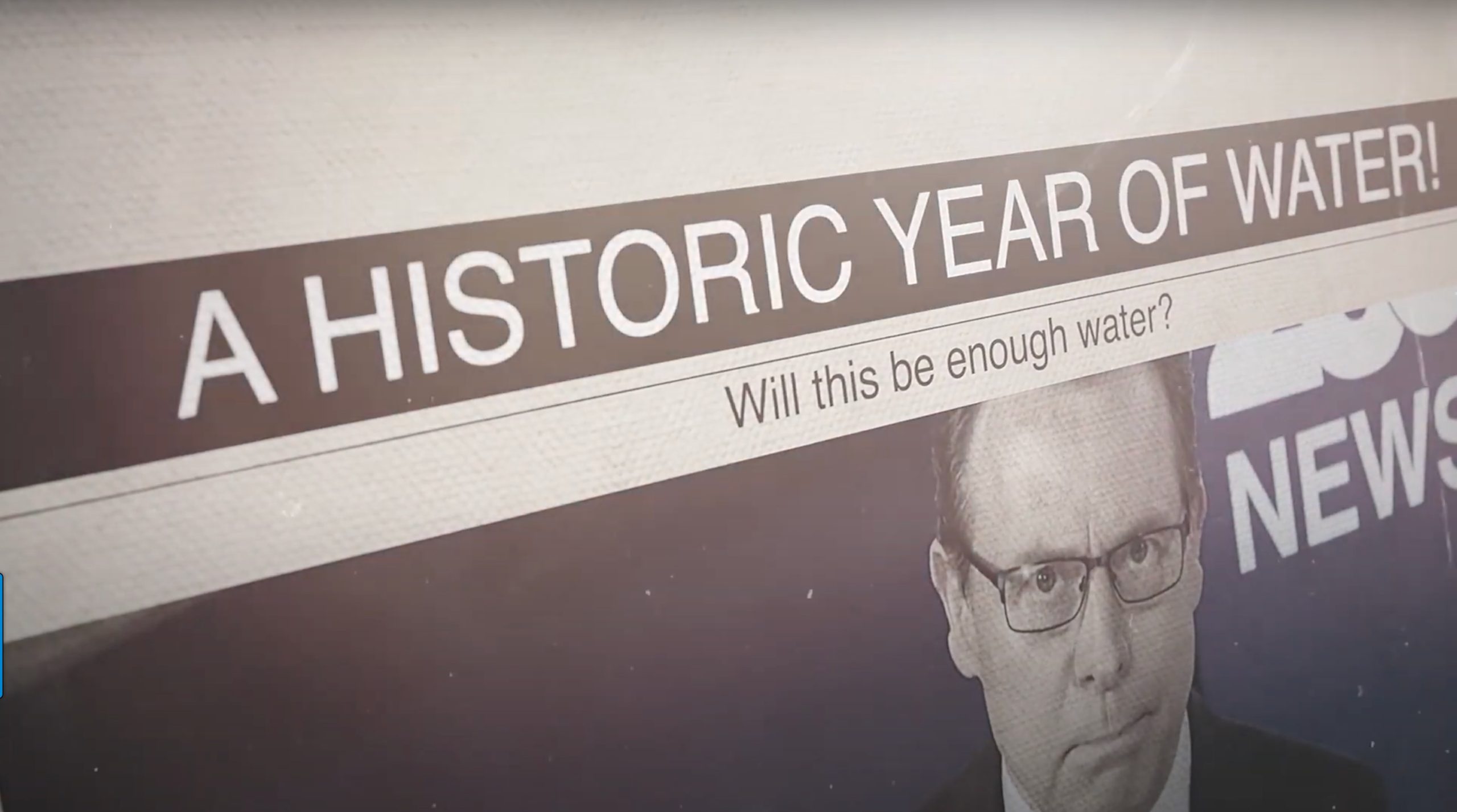 Close-up of a news ticker saying "a historic year of water!" above a news anchor with a concerned expression, questioning "will this be enough water for home improvement?